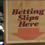 Sign at a track that reads "Betting Slips Here"